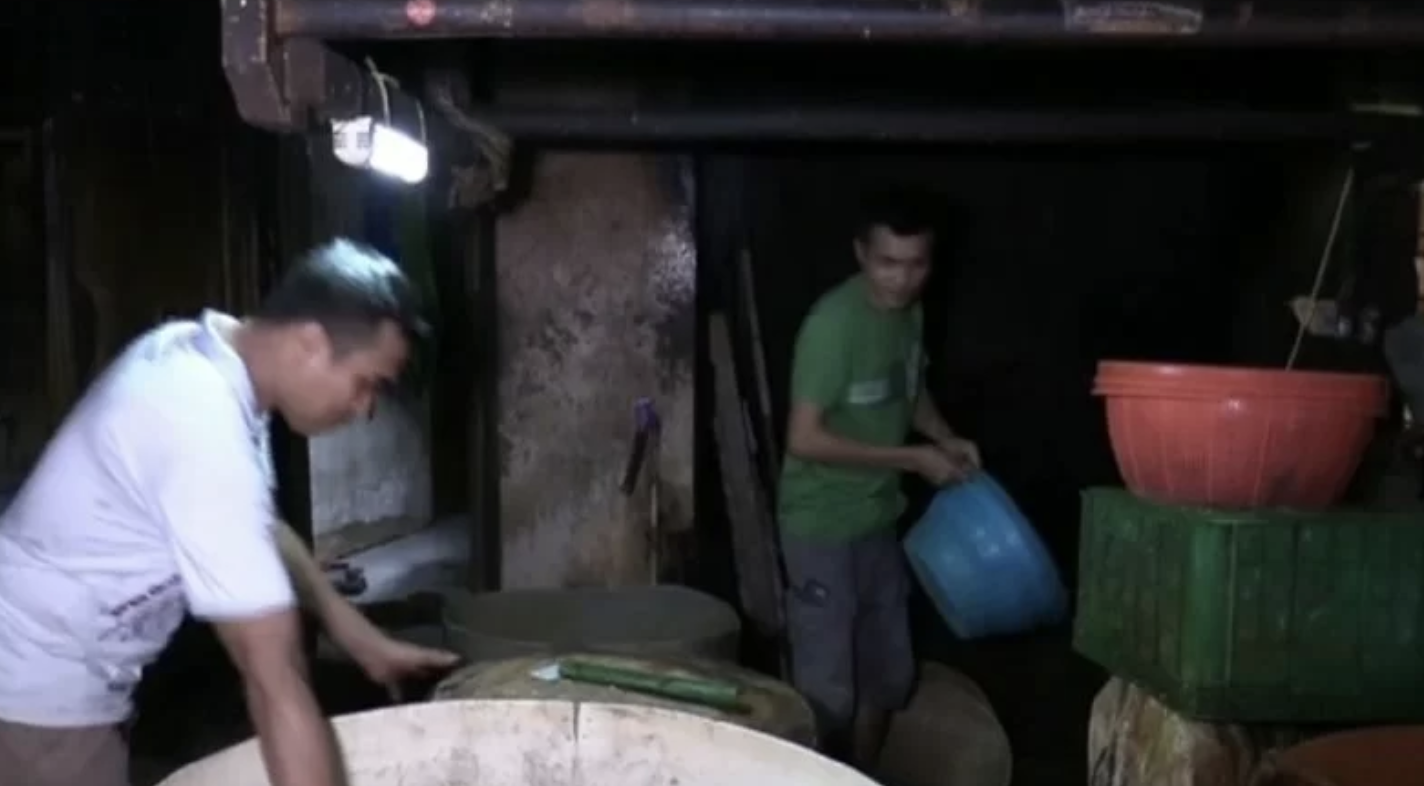 Perajin tahu tempe di Johar Baru, Jakarta Pusat, merapihkan ember dan mesin penggiling kedelai sebagai persiapan untuk aksi mogok produksi selama tiga hari di Jakarta, Minggu (20/2/2022)