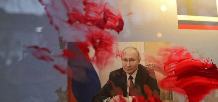 Cat merah terlihat dioleskan di atas potret Presiden Rusia Vladimir Putin selama protes anti-perang di luar Kedutaan Besar Rusia, setelah Rusia melancarkan operasi militer besar-besaran terhadap Ukraina, di Bucharest, Rumania, (26/2/2022).