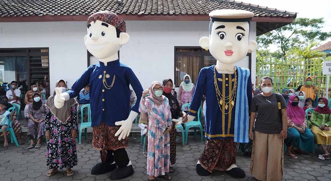 Maskot ondel-ondel di sentra vaksinasi menjadi salah satu daya tarik bagi warga untuk menjalani vaksinasi di Balai Desa Bulungcangkring. foto : ist