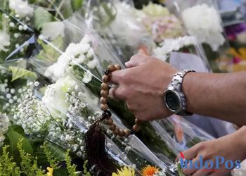 Orang-orang meletakkan karangan bunga sebagai penghormatan dan turut berduka di lokasi penembakan mantan PM Jepang Shinzo Abe saat berkampanye untuk pemilu parlemen di dekat Stasiun Yamato-Saidaiji, Nara, Jepang, Sabtu (9/7/2022). Shinzo Abe meninggal dunia akibat insiden penembakan tersebut.