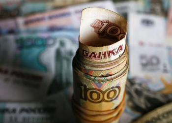 Uang kertas rubel Rusia yang digulung di atas meja di Warsawa, Polandia, 22 Januari 2016.