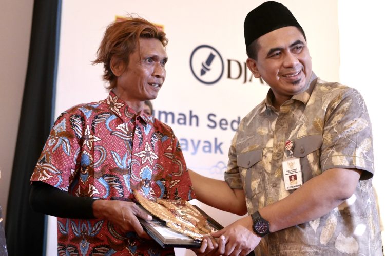 Triyono (kiri), warga Desa Getas Pejaten, Kecamatan Jati, Kabupaten Kudus merasa bahagia dan haru saat menerima bantuan dari PT Djarum berupa Rumah Sederhana Layak Huni dan mendapat ucapan selamat dari Wakil Gubernur Jawa Tengah, H. Taj Yasin Maimoen (kanan).